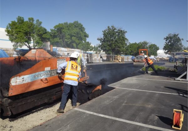 The DRYCO team laying recycled asphalt in a parking lot.
