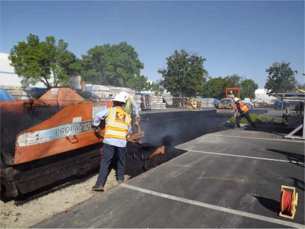 The DRYCO team laying recycled asphalt in a parking lot.